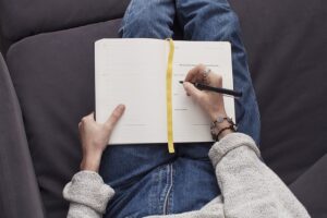 person sitting on a couch journaling
